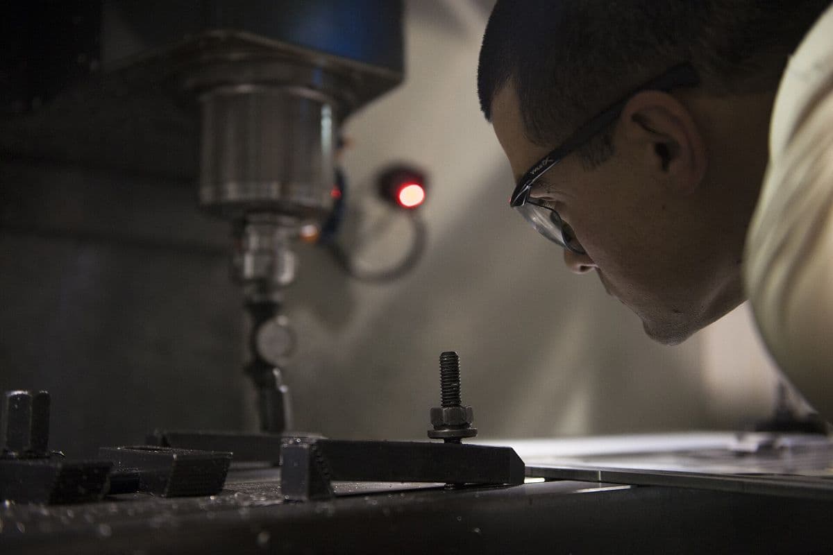 Machinist indicating a fixture on the table of a CNC mill